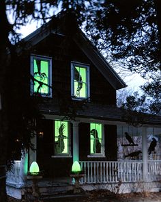 a creepy house with green lights on the windows