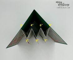 an origami paper airplane with measurements on it