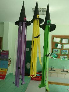 three witches hats hanging from the ceiling in a room with green tile flooring and white walls