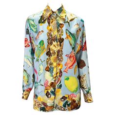 Presenting a baby blue aquatic motif silk button-down Gucci shirt. From the Spring/Summer 1992 collection, this fabulous top appeared on the season's runway and in the season's ad campaign. Covered in shells and different aquatic life, this fabulous shirt is made complete with gold 'GG' Gucci buttons at the neck and cuffs. Approximate measurements: Size - IT38 22.5" shoulder to cuff 19.5" underarm to cuff 28" shoulder to hem 41" bust 41" waist 100% silk Luxury Fitted Gucci Blouse, Gucci Summer Workwear Tops, Designer Printed Summer Shirt, Designer Summer Printed Blouse, Luxury Printed Blouse For Spring, Elegant Gucci Button-up Blouse, Designer Summer Floral Print Shirt, Designer Floral Print Summer Shirt, Luxury Silk Summer Blouse