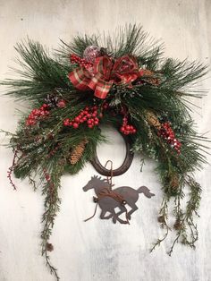 a christmas wreath hanging on the side of a wall with an ornament attached to it