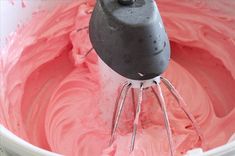 a mixer with pink frosting in it