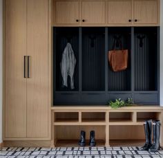 a wooden bench sitting in the middle of a room filled with boots and coats on it