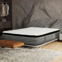 a mattress sitting on top of a wooden floor next to a dresser and bed in a room