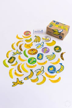 a bunch of banana stickers sitting on top of a white table next to a box