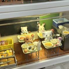 there are many stuffed animals sitting at the breakfast buffet table with food in front of them