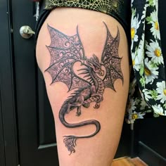 a woman's thigh with a dragon tattoo on it