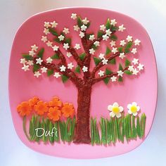 a pink plate with white flowers and a tree on the side that says daff