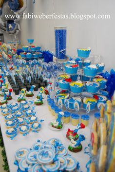 a table filled with blue and white cupcakes