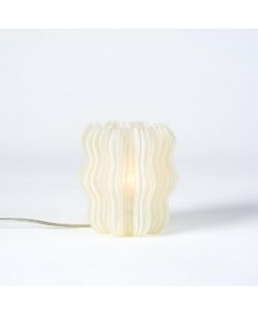 a lamp that is on top of a white surface with a long cord attached to it