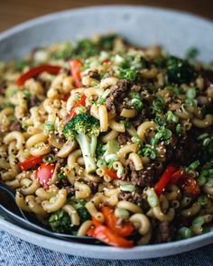 a bowl filled with noodles and vegetables on top of a table