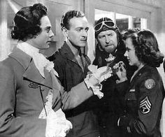 an old black and white photo of people in uniform talking to each other while holding something