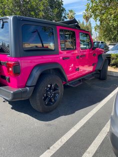 a bright pink jeep parked in a parking lot