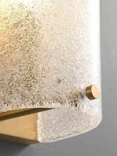 a close up of a light fixture on a wall with water droplets all over it