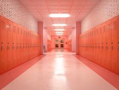 an empty hallway with orange lockers in it