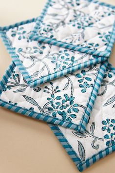 three blue and white quilted coasters sitting on top of a table next to each other