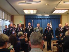 several police officers standing in front of a group of people with medals on their necks