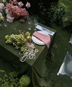 the table is set with grapes and wine glasses for an elegant dinner or party setting