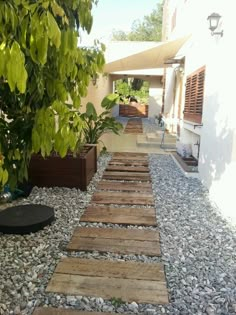 a walkway made out of wooden planks in front of a house