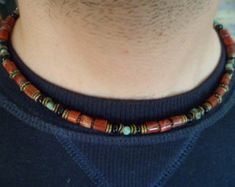 a man wearing a necklace with beads on it