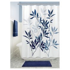 a blue and white shower curtain in a bathroom with a rug on the floor next to it