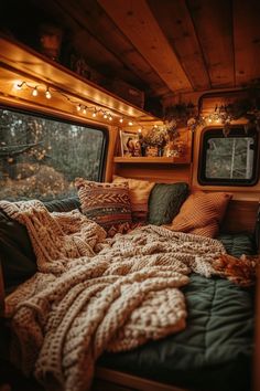 a bed in the back of a truck with blankets and pillows on top of it