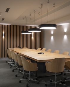 an empty conference room with wooden tables and chairs