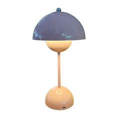 a lamp that is sitting on top of a white surface with a blue shade over it