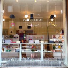 a store front window with many items in the display case and lights hanging from the ceiling