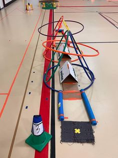 an indoor play area with toys on the floor and in the background is a basketball court