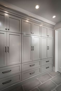 a kitchen with white cabinets and gray flooring