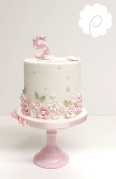 a white cake with pink flowers and the number five on top