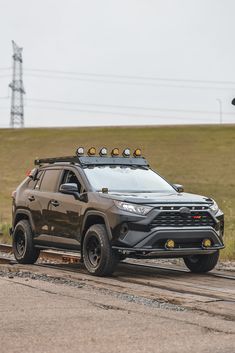 a gray truck is parked on the side of the road near an electrical pole and power lines