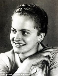 an old black and white photo of a smiling woman with her hands on her chest