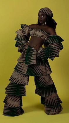 a woman in an african inspired dress poses for a photo with her hands on her hips