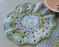 a crocheted dishcloth with a bowl on it and a cup in the middle