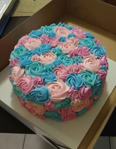 there is a large cake with pink and blue frosting