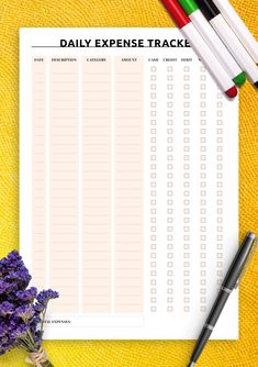 the daily exercise tracker is next to some markers and pens on a yellow cloth with flowers