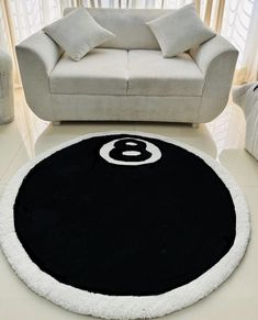 a white couch sitting next to a black and white rug on top of a floor