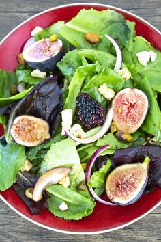 a salad with figs and greens in a red bowl