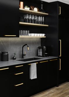 a kitchen with black cabinets and gold trim