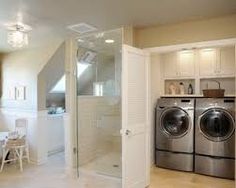 a washer and dryer in a room next to a kitchen with white cabinets