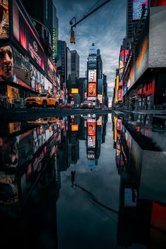 a city street filled with lots of tall buildings next to a body of water at night