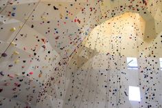 an indoor climbing wall with lots of different colored rocks on the walls and in the ceiling