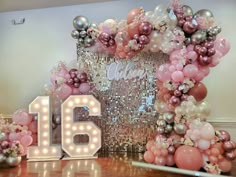 a large number is surrounded by balloons and streamers in pink, silver and white colors