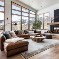 a living room filled with furniture and a fire place in front of a large window