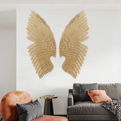 a living room with two couches and an angel wings wall decoration on the wall