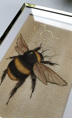 a painting of a bee on display in a frame