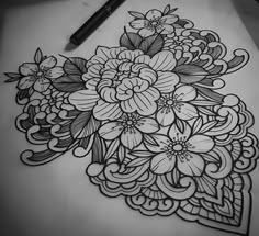 a drawing of flowers on paper next to a pen