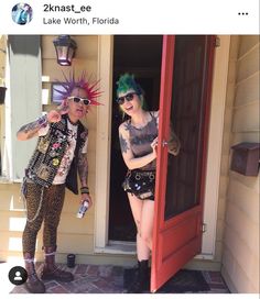 two people standing in front of a red door with weird hair and piercings on